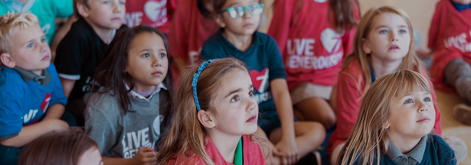 group of young students sitting on ground