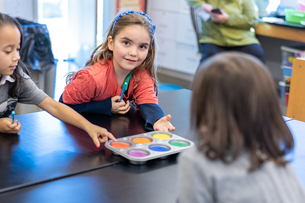 girl smiling at desk in classroom