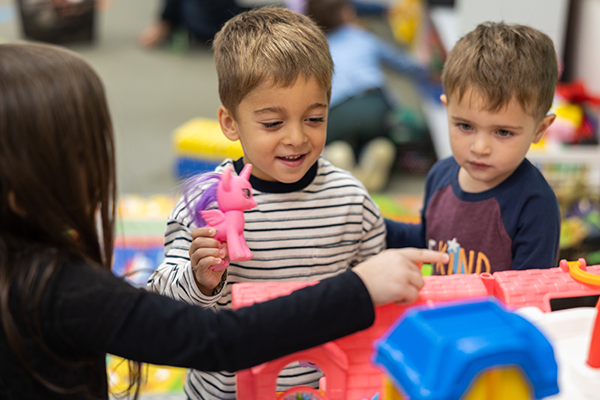 toddler playing with toys in classroom