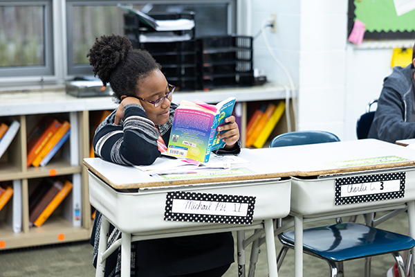 student reading at classroom desk