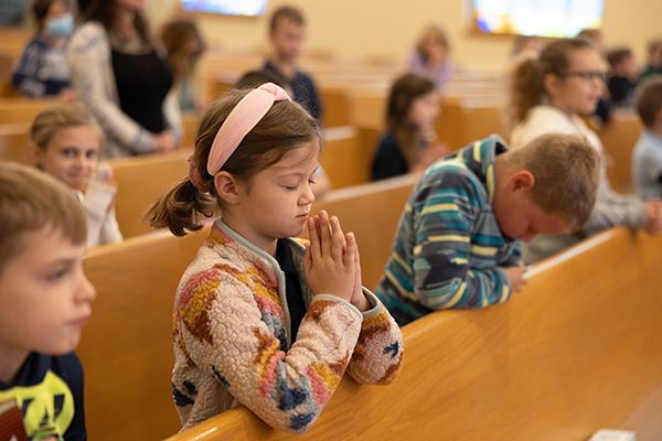 girl praying church pew