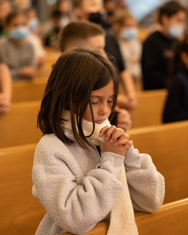 girl praying in church pew